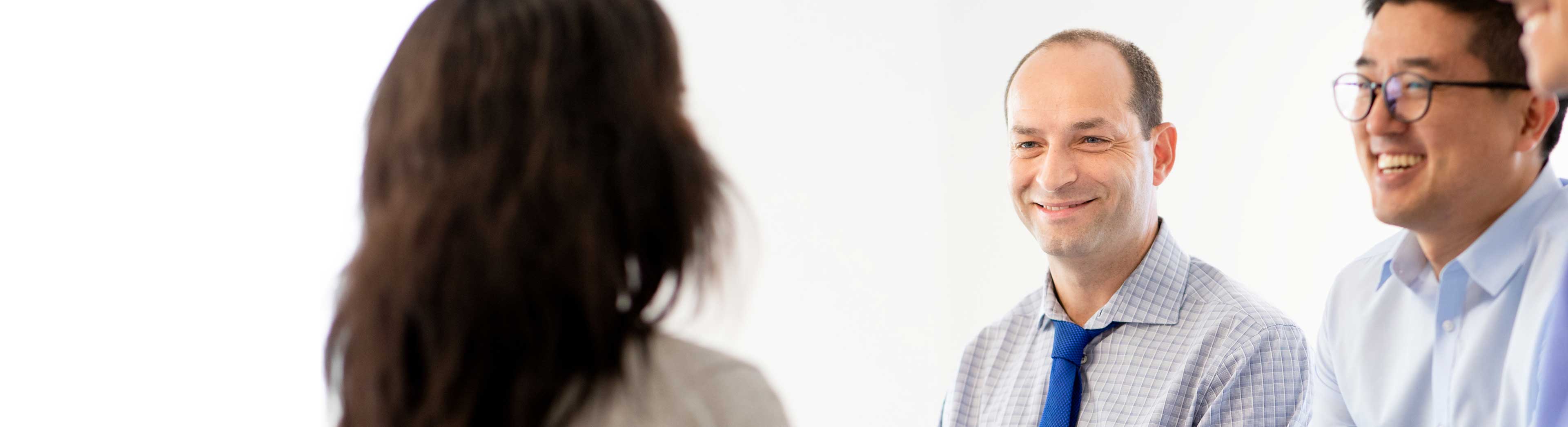 Tree colleagues in a discussion in the office - one woman and 2 men